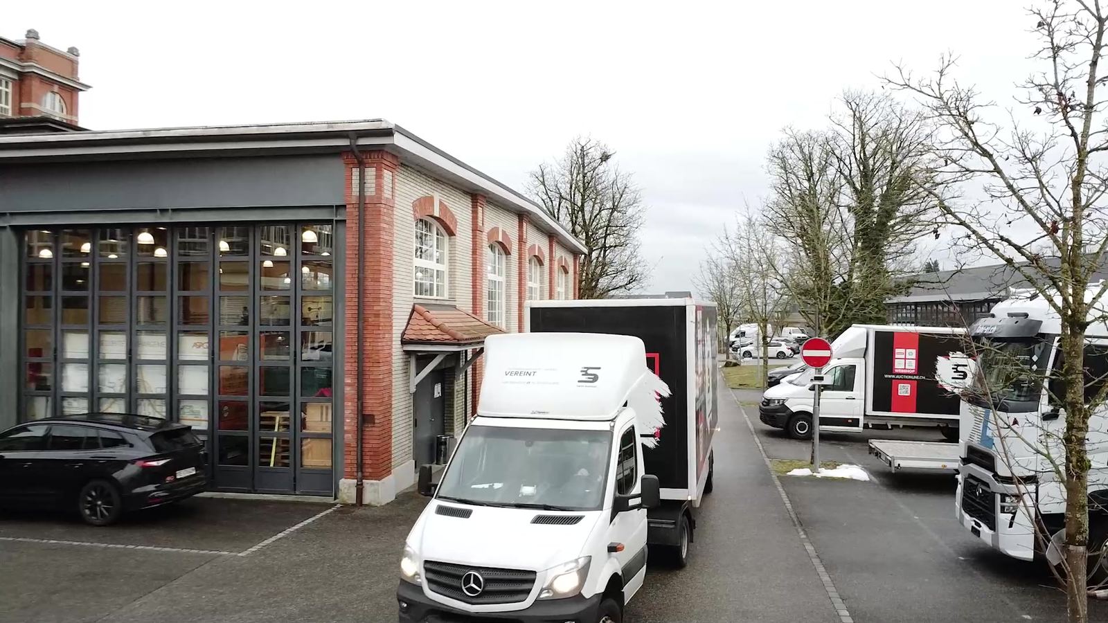 Delivery vans and lorries of Swiss Solution Group in front of the hall