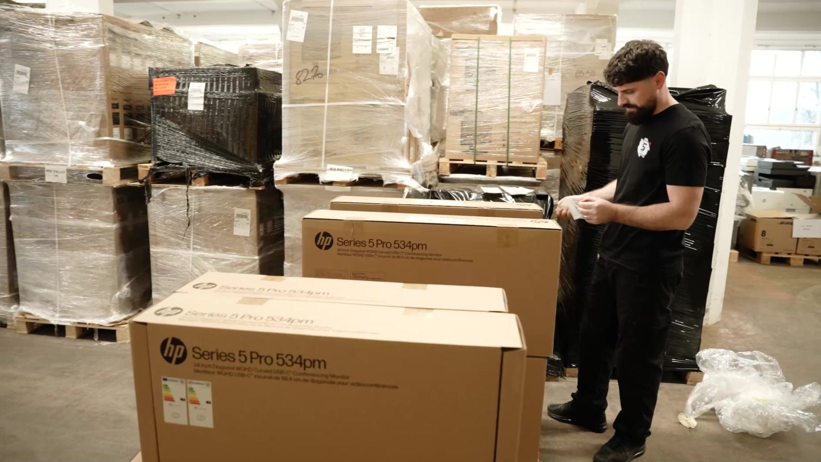 An employee checks a delivery of new monitors in the warehouse